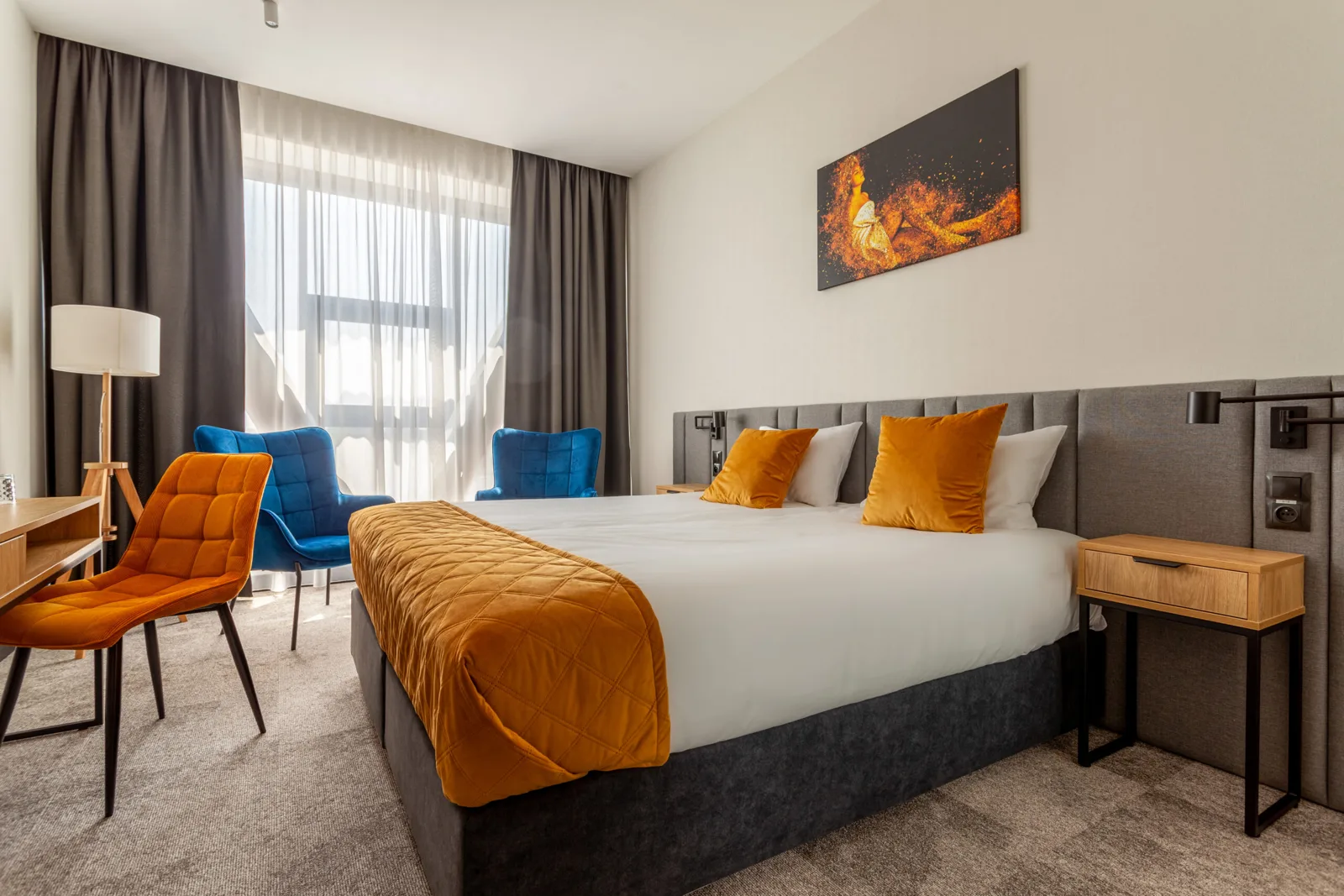Pokój King w Hotelu Sante z łóżkiem, biurkiem i fotelami przy oknie